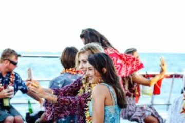 a group of people sitting next to a body of water