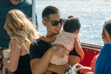 a group of people sitting next to a body of water