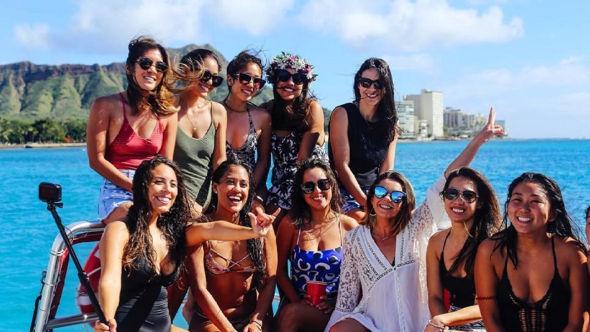 a group of people posing for a picture next to a body of water
