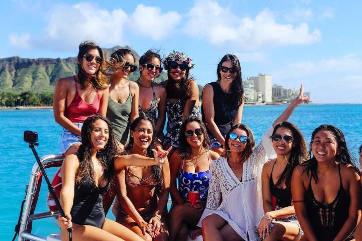 a group of people posing for a picture next to a body of water