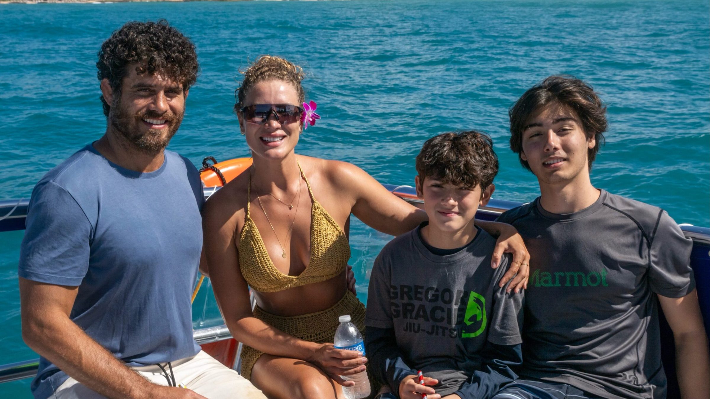 a group of people sitting next to a body of water